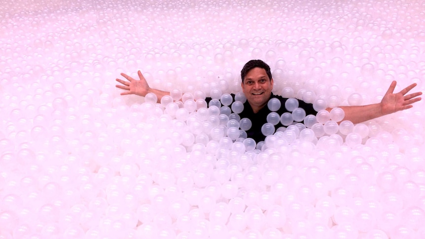 Artistic Director of the Sydney Festival, Wesley Enoch, in the ocean of balls which are part of the festival.