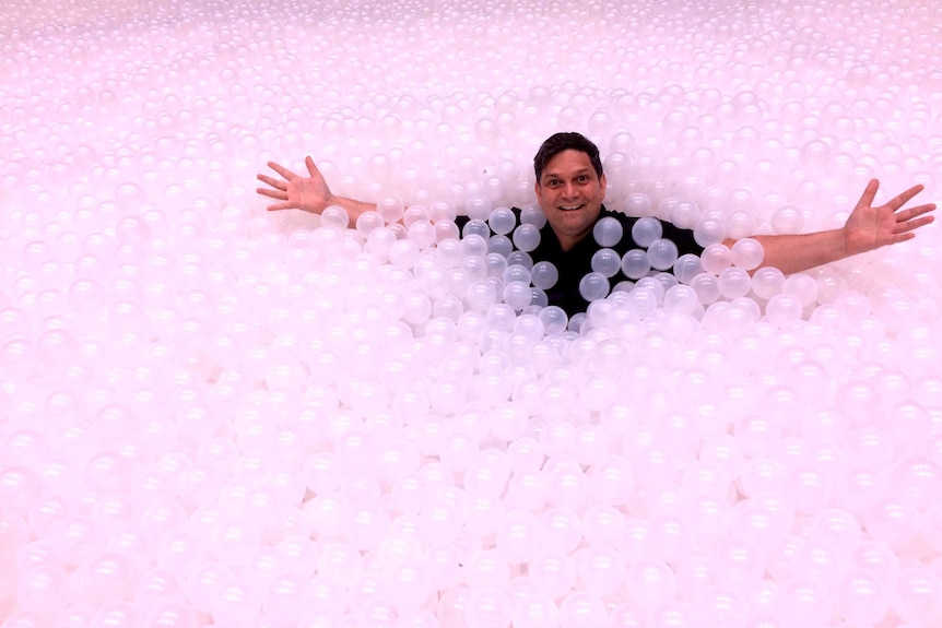 Artistic Director of the Sydney Festival, Wesley Enoch, in the ocean of balls which are part of the festival.