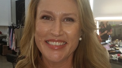 A woman wearing a white pharmacist jacket and a badge with her name