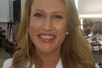 A woman wearing a white pharmacist jacket and a badge with her name