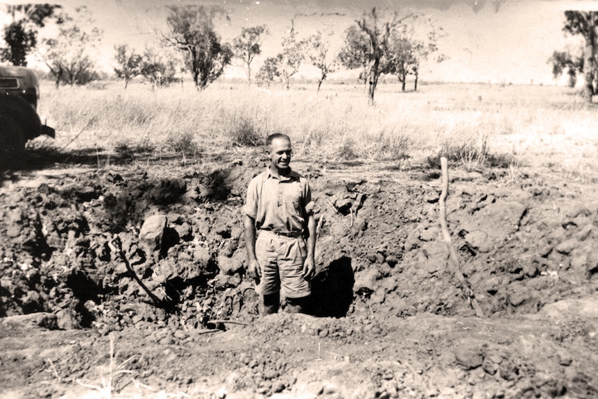 PMG worker Jack Corbell stands in a bomb crater near Katherine after the raid in 1942