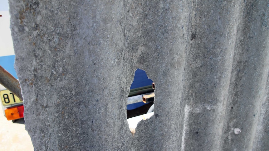 A hole in an asbestos fence opposite a primary school in WA 7 March 2013