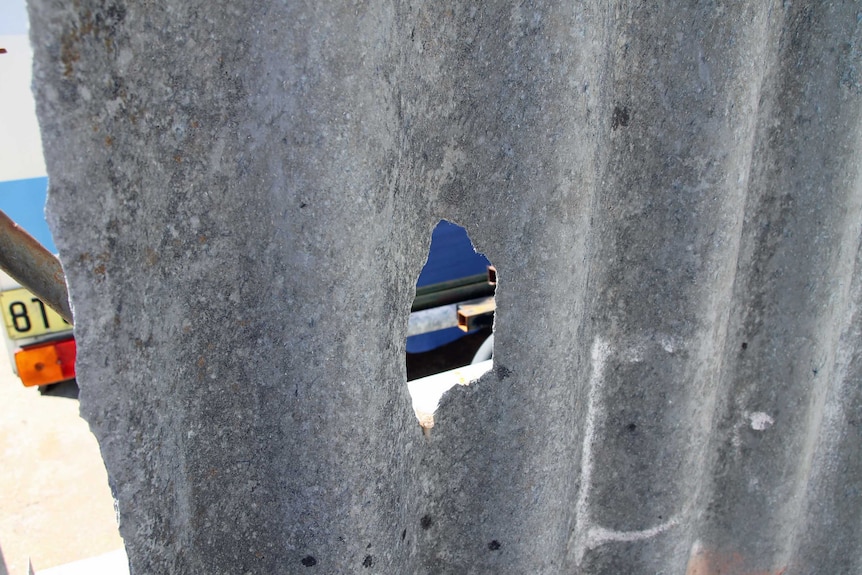 A hole in an asbestos fence opposite a primary school in WA 7 March 2013