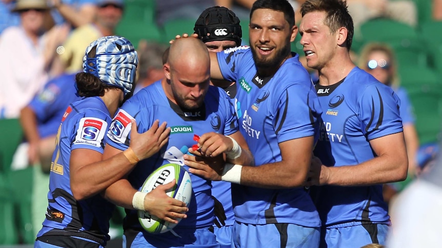 A group of Western Force players celebrate during a match.
