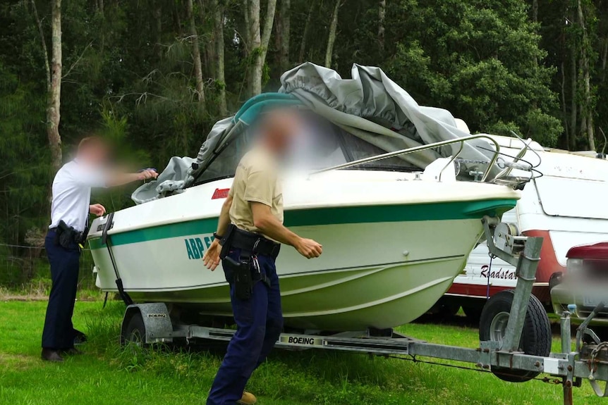 Men uncover a speed boat.