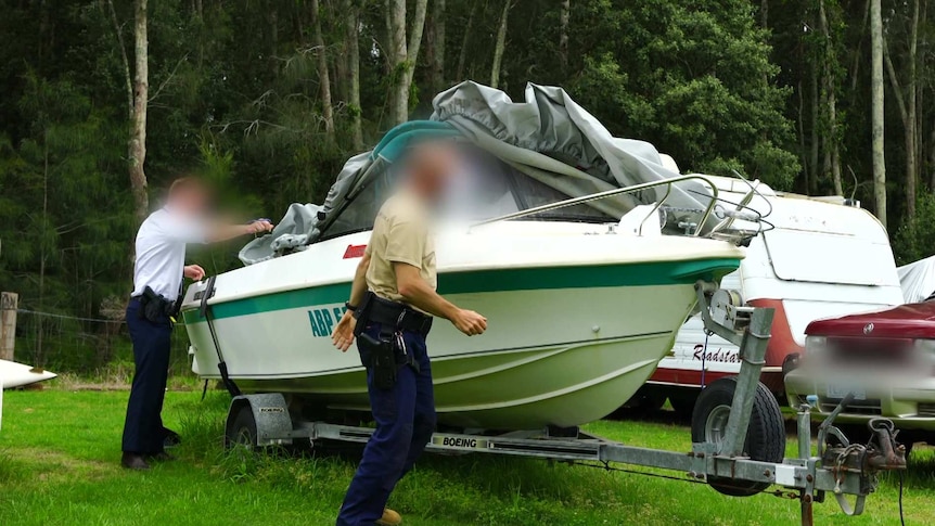 Men uncover a speed boat.