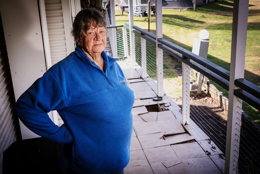 A woman next to a verandah with holes in it