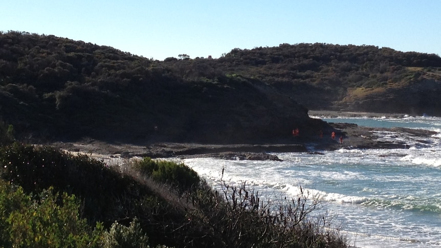 SES crews search the coastline at Flat Rock for two missing men.