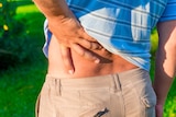 Man holding his hand sore lower back