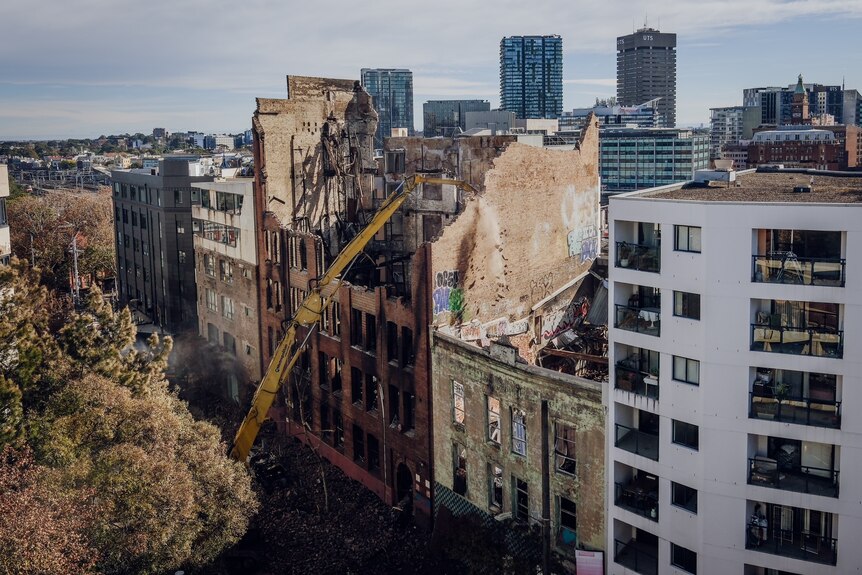 A crane smashes into a city building.