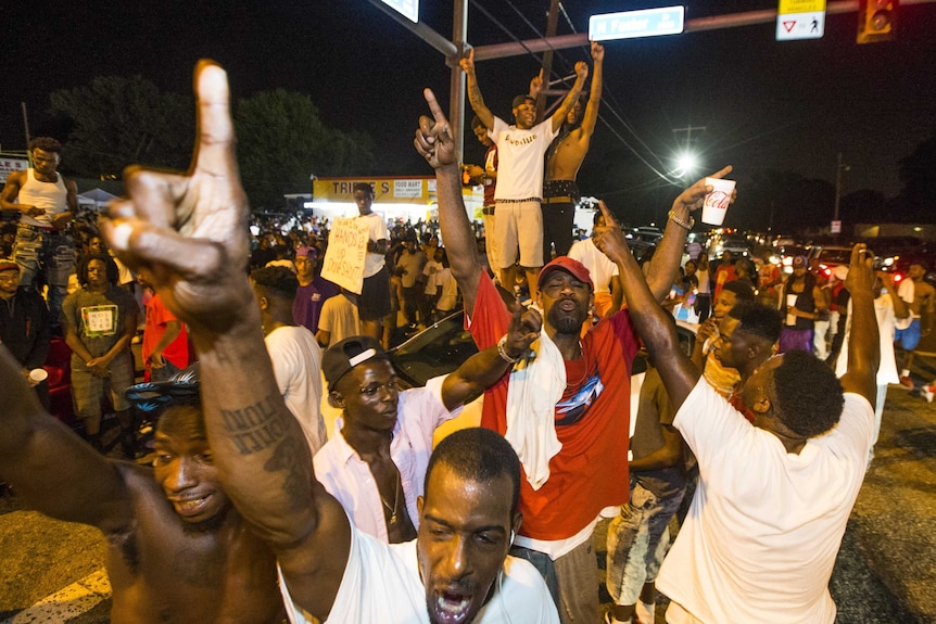 Protesters on the road, blocking an intersection.