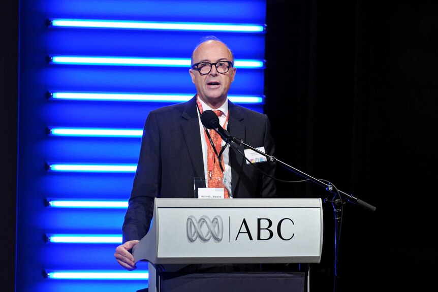 Michael Mason standing at ABC lecturn.