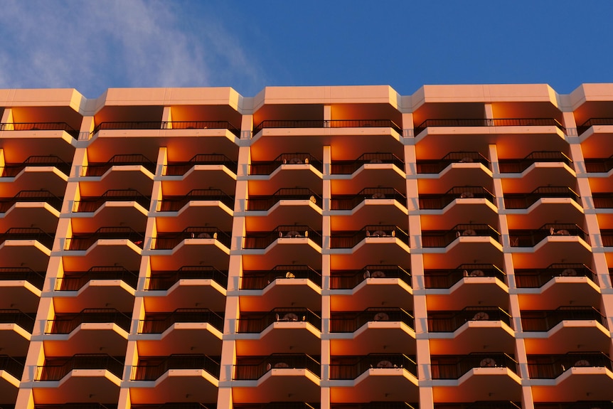 A tower block rising high into a sky of deepest azure.