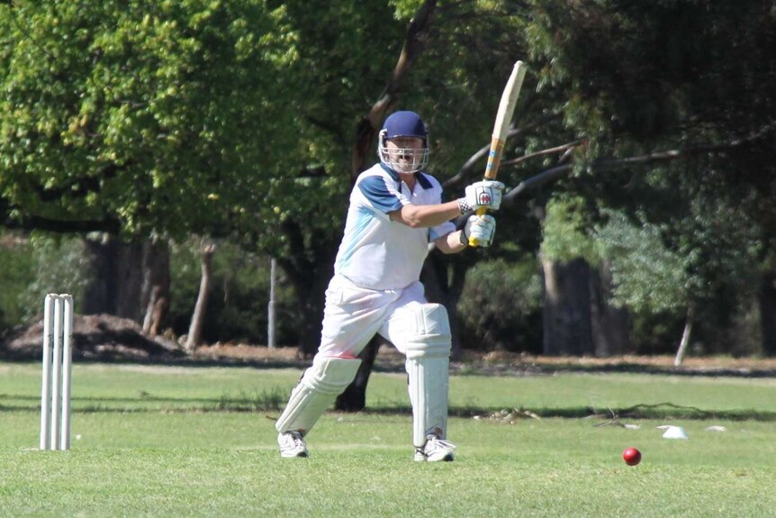 A park cricketer plays a cover drive.