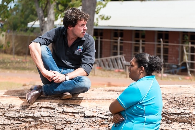 A man and a woman talk to each other. They are in a remote NT Aboriginal community.