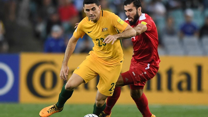 Australia's Tom Rogic runs with the ball as Syria's Tamer Mohamad challenges during the 2018 World Cup qualifying football match