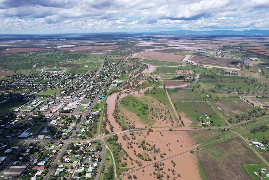 Brown floodwater inundates plains and roads.