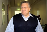 Joe Hockey, grinning and wearing a vest, arrives for a party meeting in Canberra, October 18, 2009.