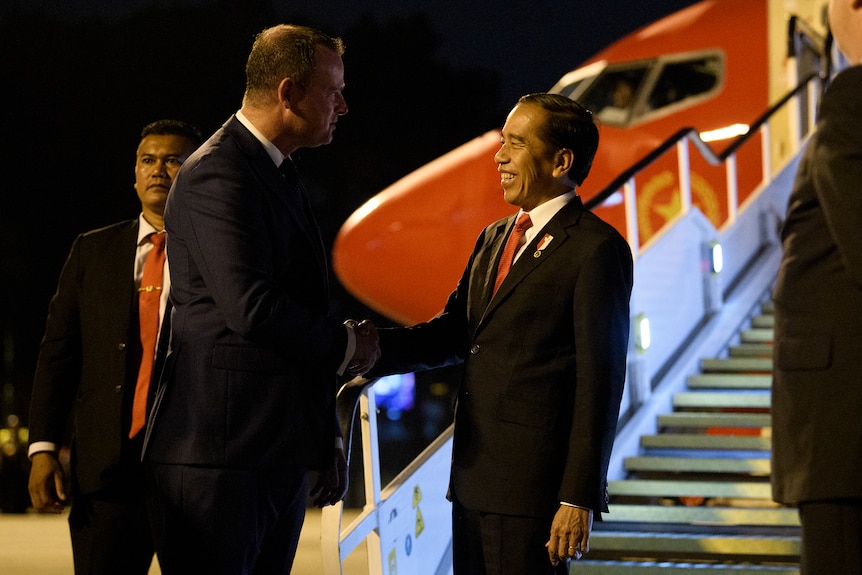 the president of indonesia arrives in australia he lands at sydney airport and is shaking an official's hand