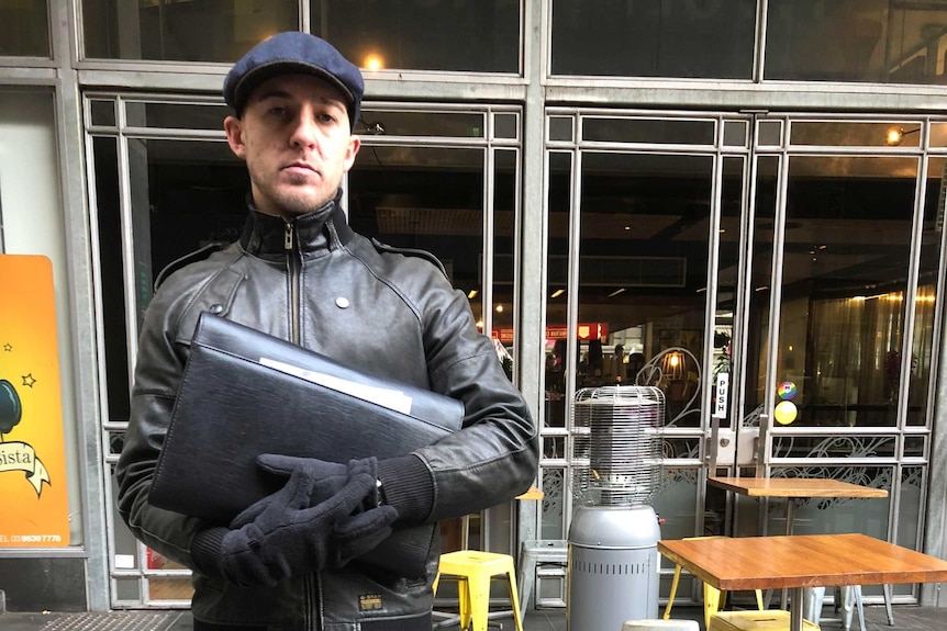 Harry Connor stands on the street outside a Melbourne laneway cafe in daylight.