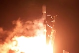 A blurry image of a spacecraft taking off in the night.
