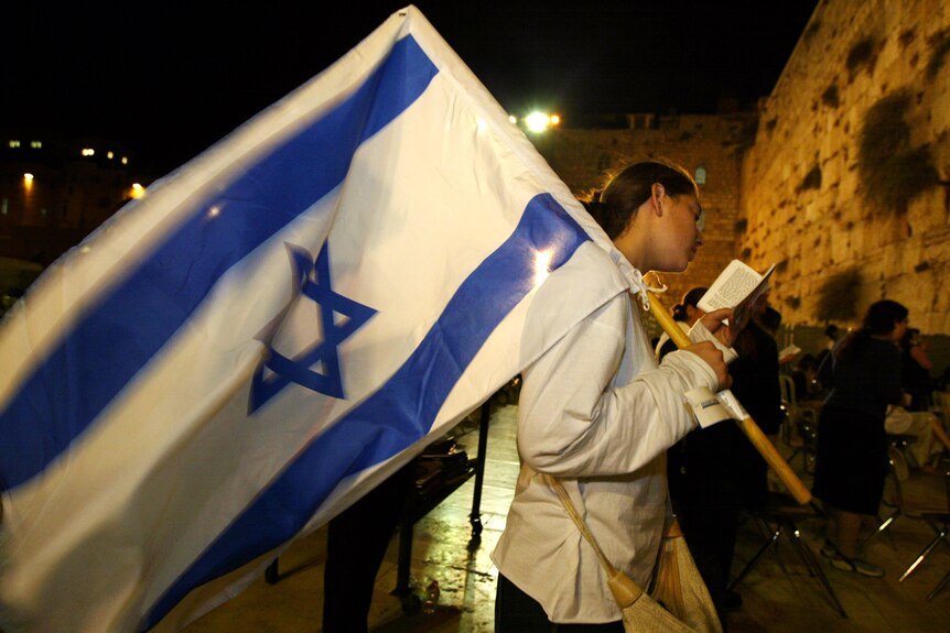 An Israeli girl reads from the Torah at the Western Wall