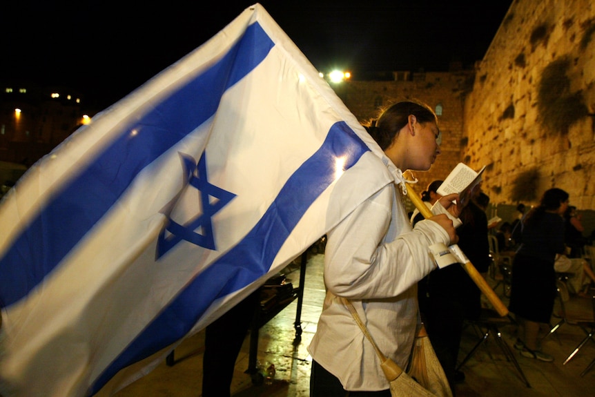 An Israeli girl reads from the Torah at the Western Wall