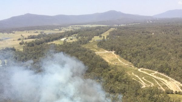 Smoke rises from the bush, as seen from an aircraft.