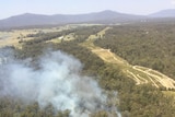 Smoke rises from the bush, as seen from an aircraft.
