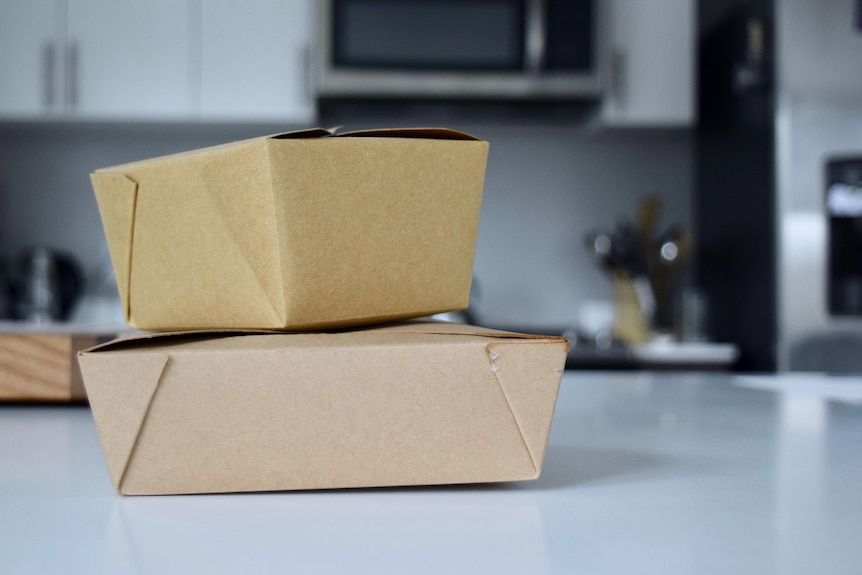 Cardboard takeaway containers on a bench.