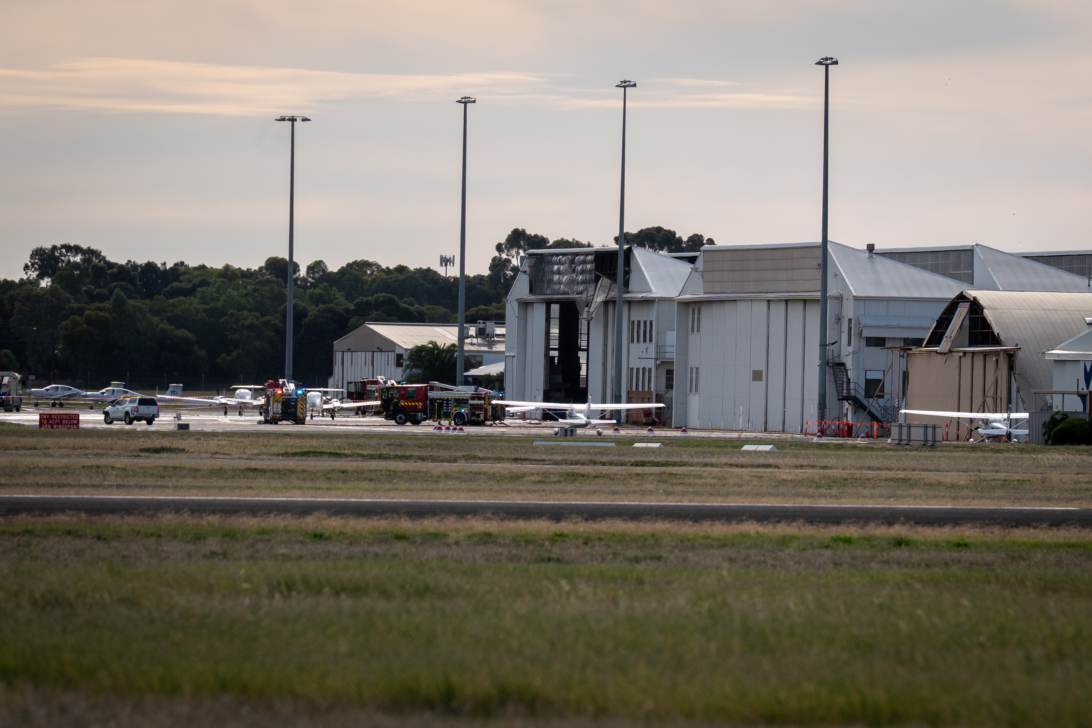 Fire trucks on a tarmac near hangars