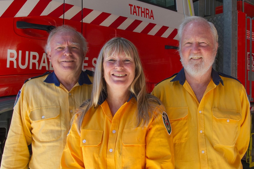 Portrait of three Tathra RFS volunteers standing next to fire truck