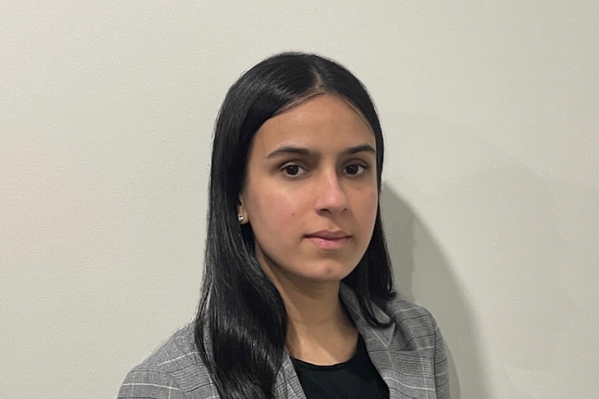 A headshot of a woman with long black hair in a blazer. 