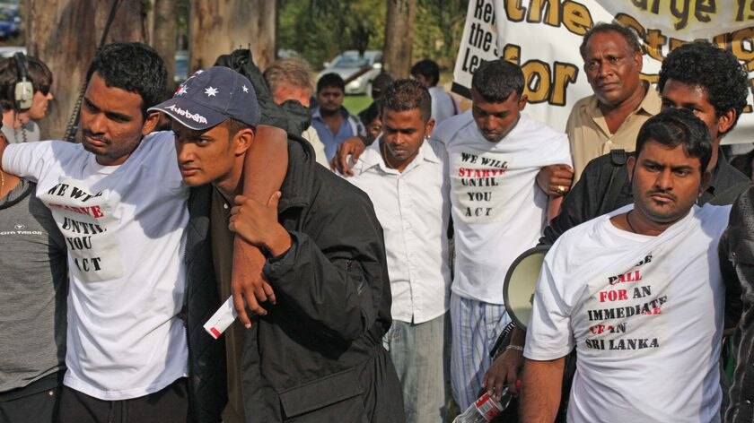 Three hunger strikers are helped by other members of the Tamil community at a protest outside the PM's residence.