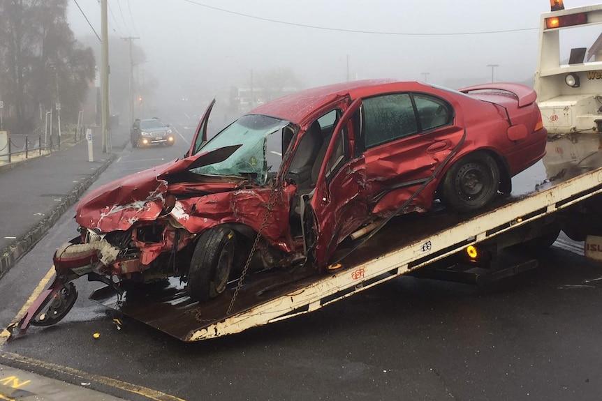 The red car involved in a fatal hit and run in Launceston is loaded onto a tow truck.