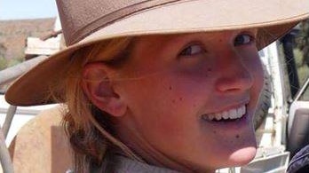 A woman wearing a cowboy hat looks back over her shoulder at the camera