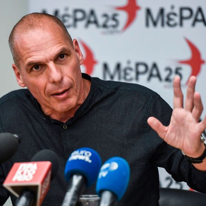 Yanis Varoufakis press conference with a banner of the Greek Mera25 party behind him