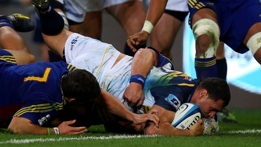 Return pays off ... George Smith bulldozes through the Highlanders' defence.