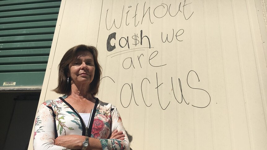Anni Brownjohn, owner of Right Food Group, standing in front of her warehouse with a scrawled message on the walls.