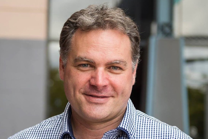 Man wearing a blue and white check shirt. 