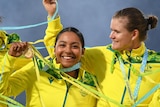 Australian cricketers stand arm in arm with their medals as streamers fly at the gold medal game at the Commonwealth Games.