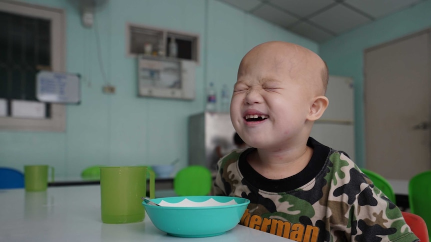 Grammy smiles in his new kindergarten as he wears a green shirt