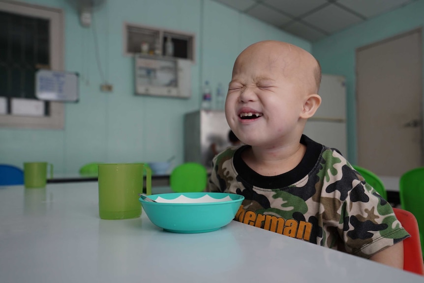 Grammy smiles in his new kindergarten as he wears a green shirt