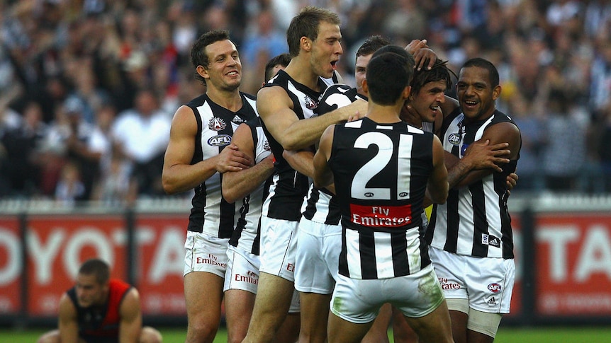 Flock of Magpies ... midfielder Scott Pendlebury (c) is swamped by his team-mates after booting the final goal after the siren.