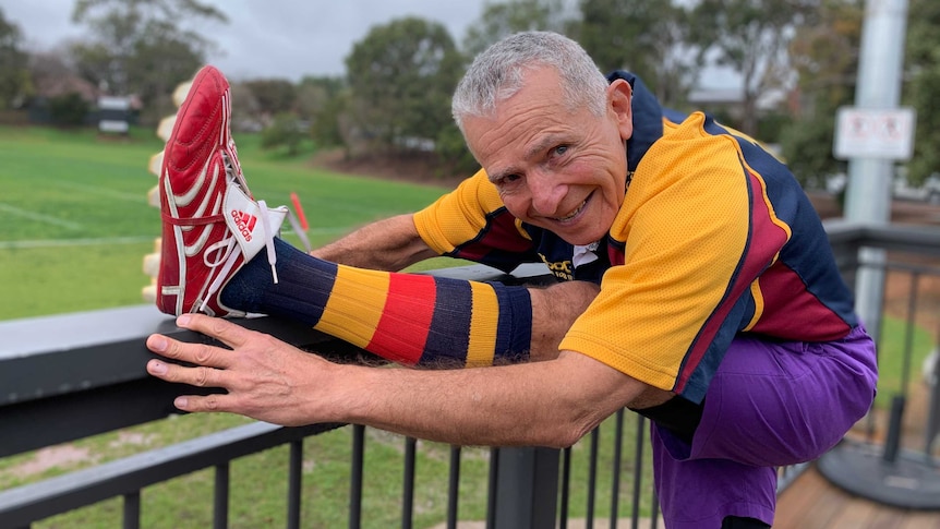 A senior rugby player stretches before his game