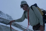 Sir Edmund Hillary with a backpack and ice pick mountain climbing.