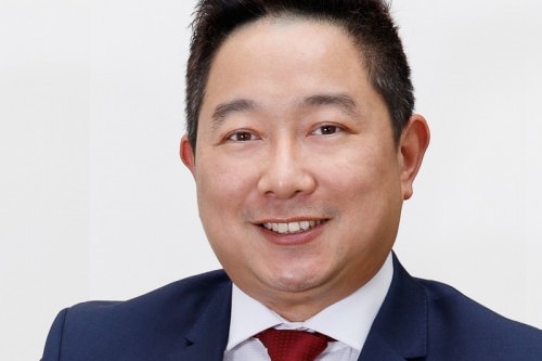 man in suit and tie smiling in a professional photo