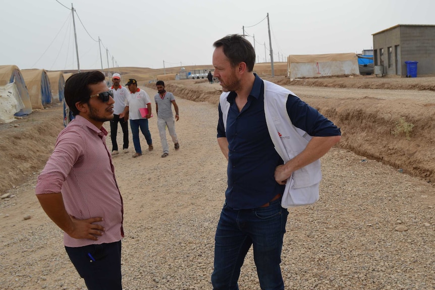 Greg Keane and a colleague on a road in the displaced person's camp in Iraq.