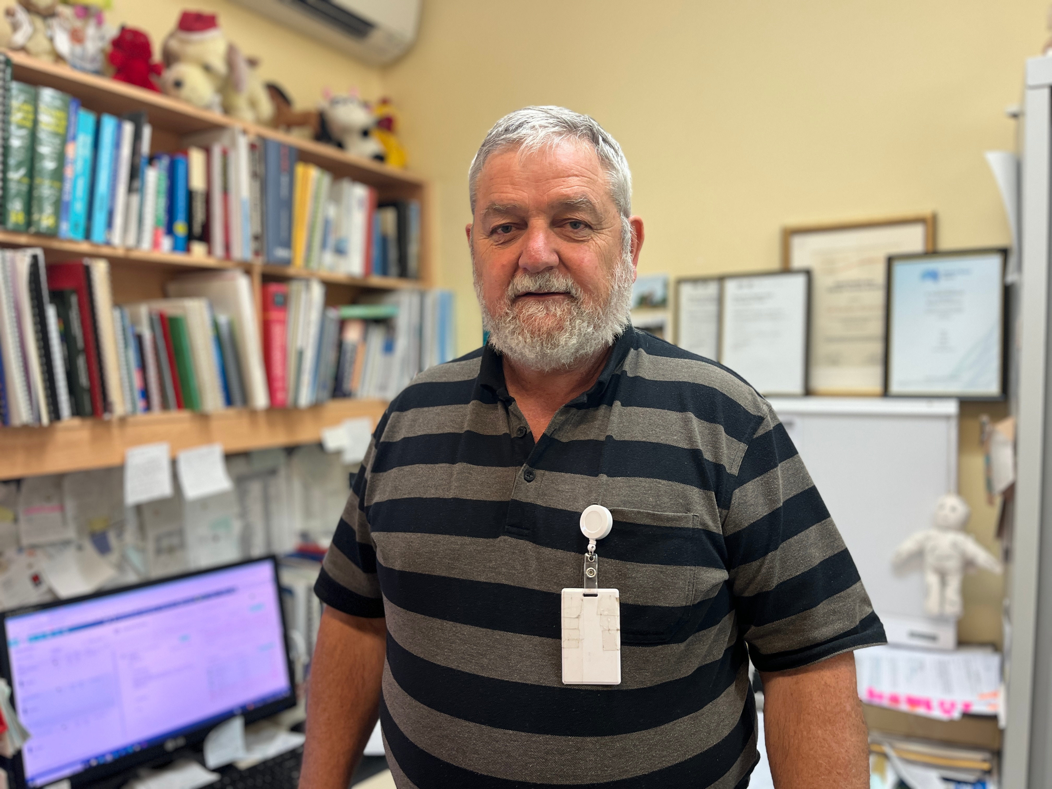 a man in a striped shirt with grey hair in an office 