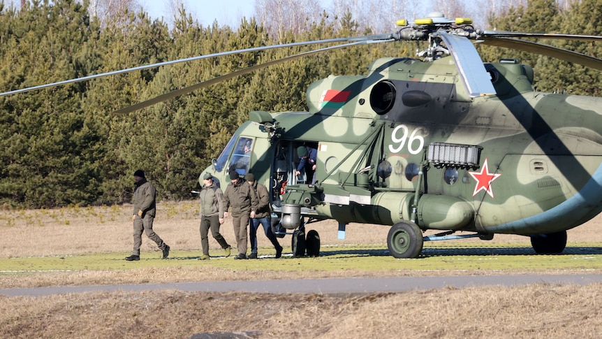 Members of the Ukrainian delegation disembark from a helicopter